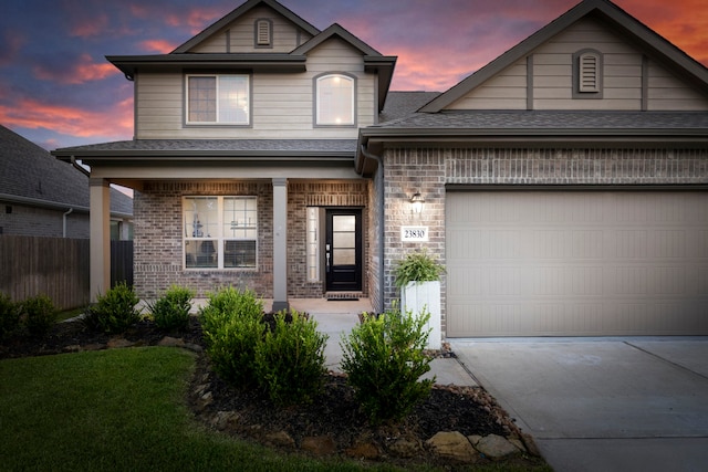 23830 Via Leoni Dr, New Caney, TX 77357 - view of front of home with covered porch, driveway, brick siding, fence, and an attached garage