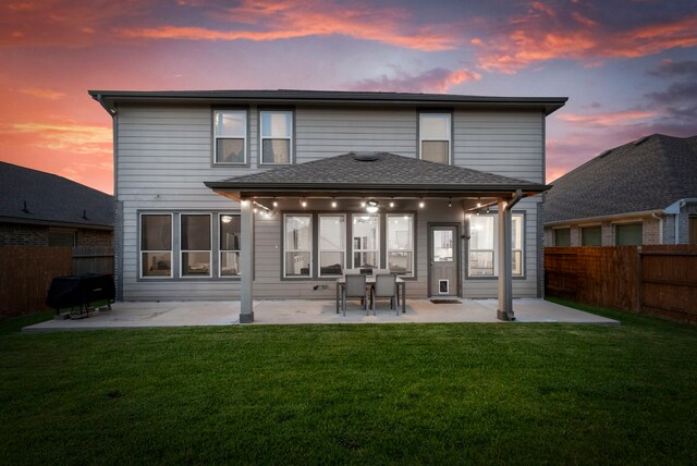 23830 Via Leoni Dr, New Caney, TX 77357 - back of house at dusk featuring a patio