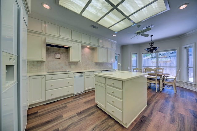 kitchen featuring visible vents, black electric cooktop, ornamental molding, light countertops, and under cabinet range hood