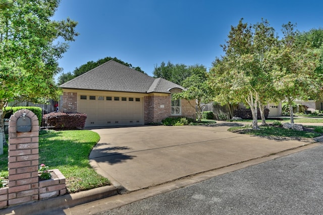 view of front of home featuring a garage, fence, concrete driveway, brick siding, and roof with shingles