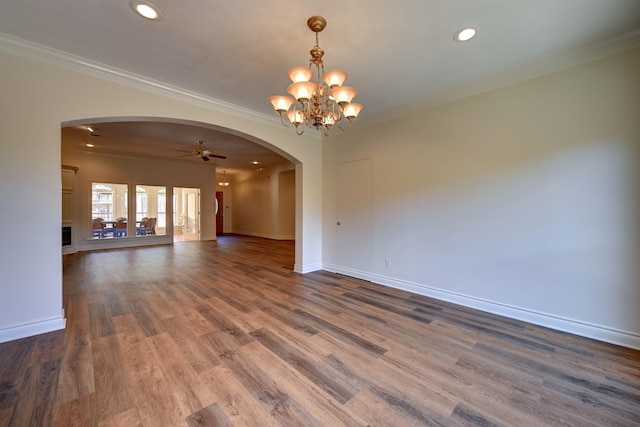 spare room with arched walkways, dark wood-style flooring, ornamental molding, and recessed lighting