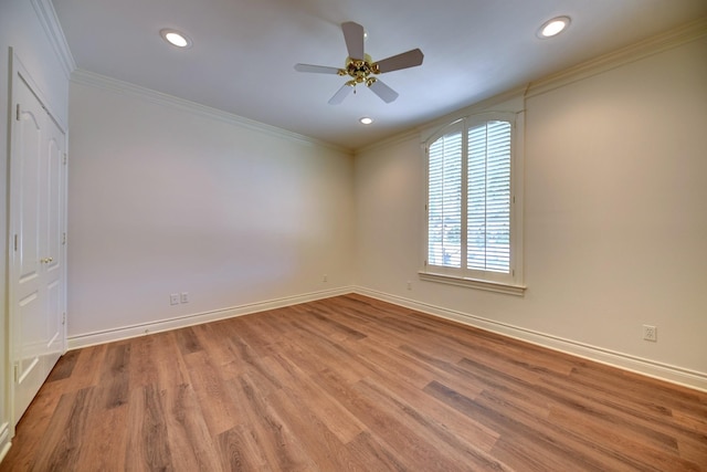 empty room with baseboards, wood finished floors, crown molding, and ceiling fan