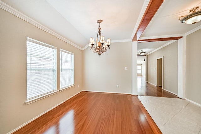 spare room featuring crown molding, a notable chandelier, and a healthy amount of sunlight