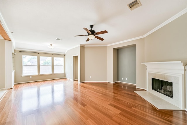 unfurnished living room featuring a ceiling fan, crown molding, light wood-type flooring, a fireplace, and visible vents