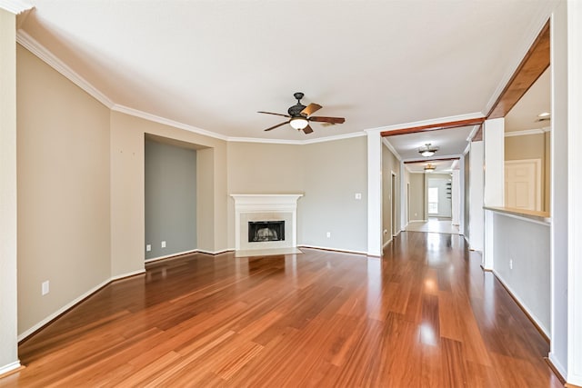 unfurnished living room with a fireplace with flush hearth, ceiling fan, ornamental molding, and wood finished floors