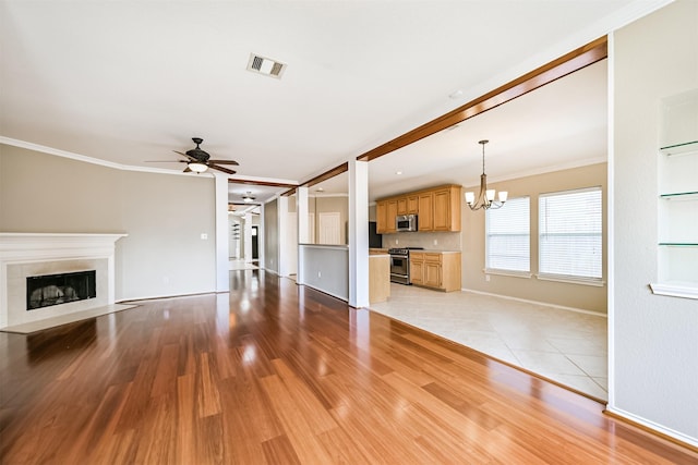 unfurnished living room with a fireplace with flush hearth, visible vents, light wood-type flooring, baseboards, and ceiling fan with notable chandelier