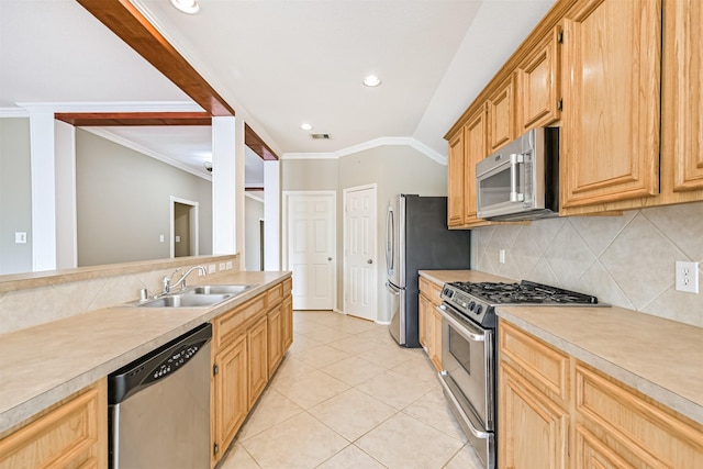 kitchen with a sink, decorative backsplash, appliances with stainless steel finishes, light countertops, and ornamental molding