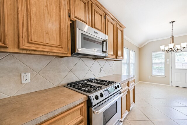 kitchen with crown molding, tasteful backsplash, a chandelier, light countertops, and appliances with stainless steel finishes