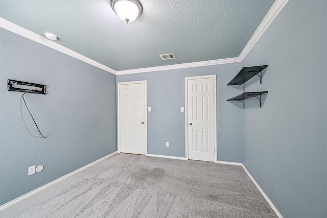 unfurnished bedroom with baseboards, ornamental molding, a textured ceiling, and visible vents