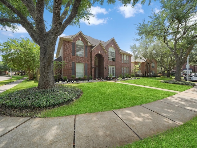 traditional-style house with a front lawn and brick siding