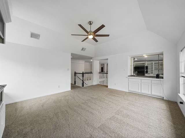 unfurnished living room featuring ceiling fan, visible vents, carpet, and lofted ceiling