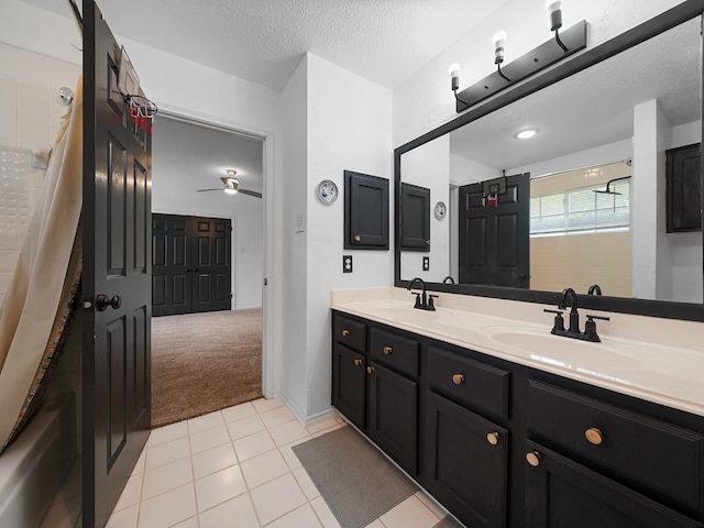 bathroom featuring double vanity, a sink, ceiling fan, and a shower