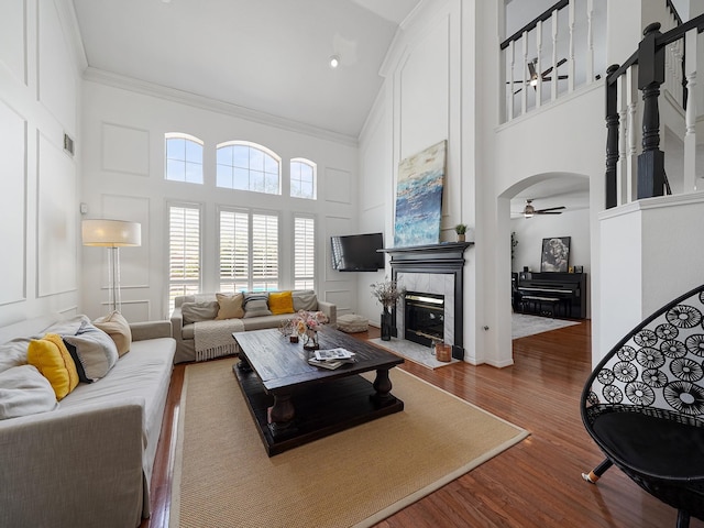 living room featuring crown molding, high vaulted ceiling, ceiling fan, and wood finished floors