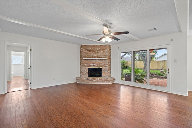 7 Colony Park Cir, Galveston, TX 77551 - unfurnished living room featuring wood finished floors, beamed ceiling, ceiling fan, visible vents, and a textured ceiling