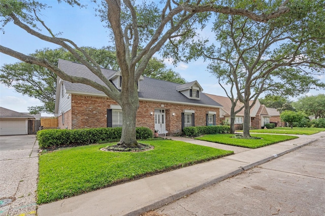 7 Colony Park Cir, Galveston, TX 77551 - view of front of home featuring brick siding, a front yard, and roof with shingles