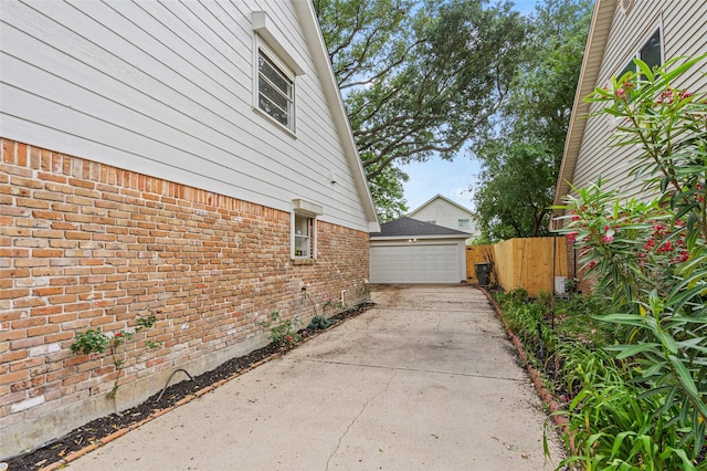7 Colony Park Cir, Galveston, TX 77551 - view of side of home featuring an outbuilding, brick siding, a garage, and fence