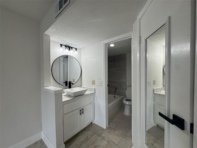 full bath with toilet, vanity, baseboards, and visible vents