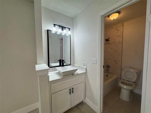 full bathroom featuring tub / shower combination, vanity, tile patterned floors, a textured wall, and baseboards
