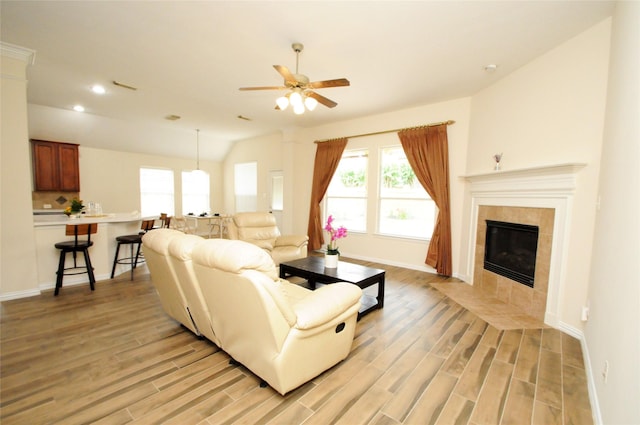 7214 Paradise Park Bnd, Richmond, TX 77407 - living room featuring recessed lighting, light wood-style floors, baseboards, a tiled fireplace, and ceiling fan