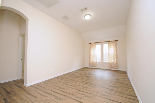 7214 Paradise Park Bnd, Richmond, TX 77407 - spare room with vaulted ceiling, light wood-type flooring, arched walkways, baseboards, and visible vents