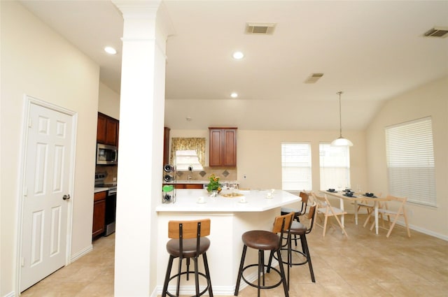 7214 Paradise Park Bnd, Richmond, TX 77407 - kitchen with decorative backsplash, stainless steel appliances, light countertops, a kitchen bar, and visible vents