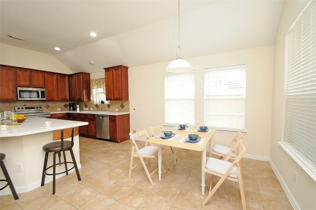 7214 Paradise Park Bnd, Richmond, TX 77407 - kitchen with a kitchen breakfast bar, light countertops, backsplash, lofted ceiling, and appliances with stainless steel finishes