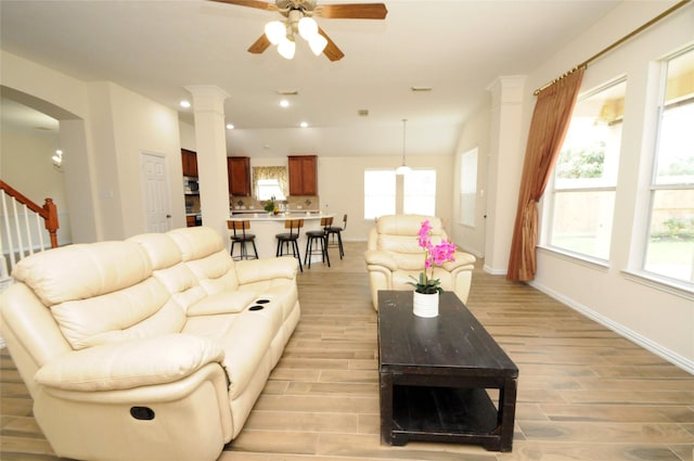 7214 Paradise Park Bnd, Richmond, TX 77407 - living area featuring light wood-style flooring, baseboards, ceiling fan, and a healthy amount of sunlight