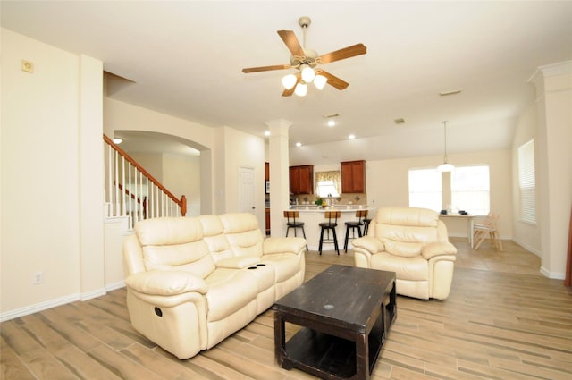 7214 Paradise Park Bnd, Richmond, TX 77407 - living room with baseboards, arched walkways, a ceiling fan, and light wood-type flooring