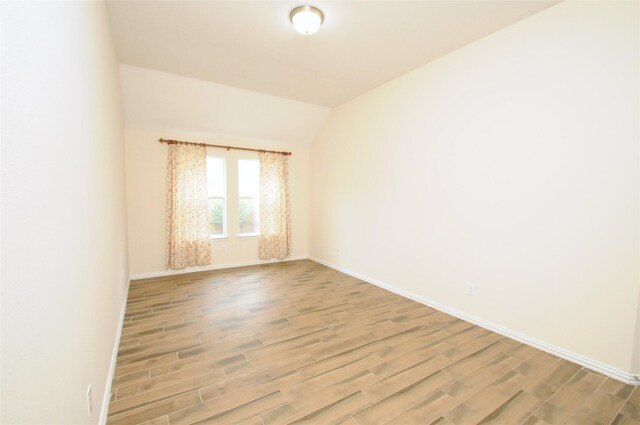 7214 Paradise Park Bnd, Richmond, TX 77407 - unfurnished room featuring baseboards, lofted ceiling, and light wood-type flooring