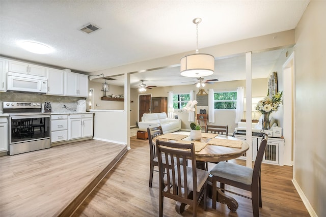 27011 Azalea Ct, Magnolia, TX 77354 - dining area featuring light wood-style floors, visible vents, baseboards, and ceiling fan