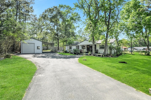 27011 Azalea Ct, Magnolia, TX 77354 - single story home with a detached garage, a front lawn, driveway, an outbuilding, and a porch