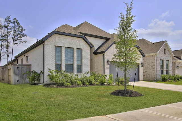 1919 Hickory Grove Ln, Tomball, TX 77375 - french country inspired facade featuring an attached garage, driveway, a front lawn, and brick siding
