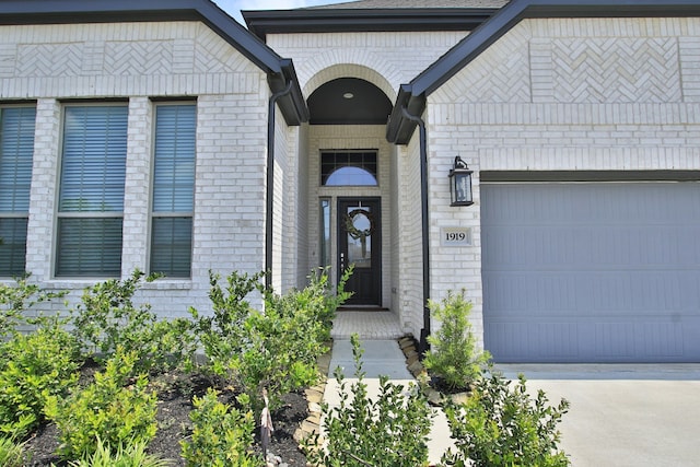 1919 Hickory Grove Ln, Tomball, TX 77375 - doorway to property featuring a garage, brick siding, and concrete driveway