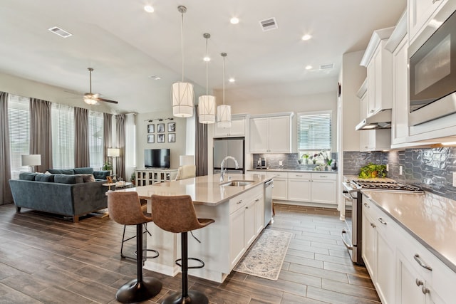 1919 Hickory Grove Ln, Tomball, TX 77375 - kitchen featuring a sink, open floor plan, stainless steel appliances, backsplash, and a breakfast bar area
