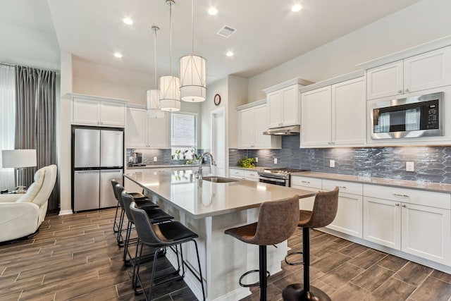 1919 Hickory Grove Ln, Tomball, TX 77375 - kitchen featuring a sink, wood tiled floor, appliances with stainless steel finishes, and under cabinet range hood