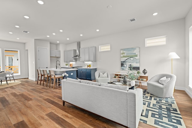 living room with recessed lighting, baseboards, visible vents, and light wood-style flooring