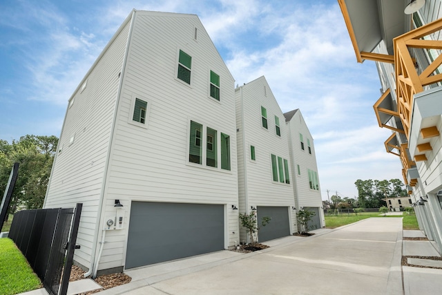 view of side of property featuring an attached garage and concrete driveway