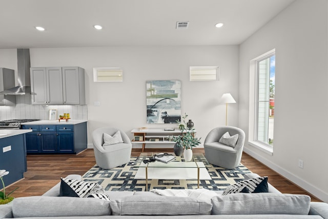 living room featuring recessed lighting, visible vents, plenty of natural light, and dark wood-type flooring