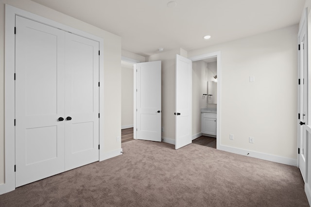 unfurnished bedroom with carpet floors, recessed lighting, baseboards, ensuite bathroom, and a closet