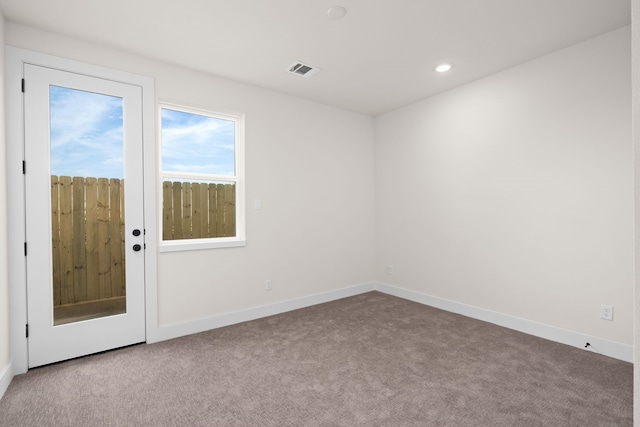 carpeted spare room featuring baseboards, recessed lighting, and visible vents