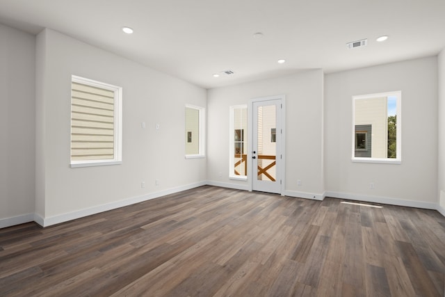 empty room featuring dark wood-style flooring, visible vents, french doors, and recessed lighting