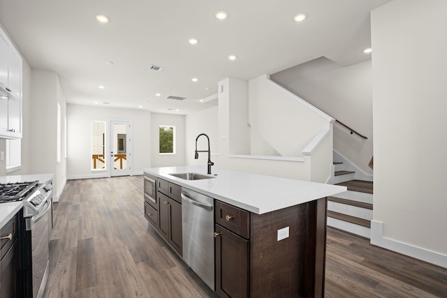 kitchen featuring recessed lighting, light countertops, white cabinets, a sink, and stainless steel appliances