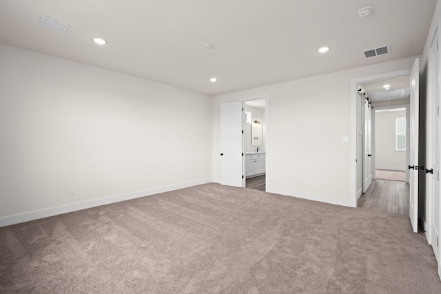 unfurnished bedroom featuring visible vents, carpet, and attic access