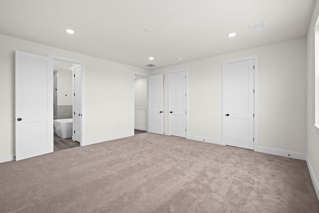 unfurnished bedroom with carpet flooring, multiple closets, recessed lighting, baseboards, and visible vents