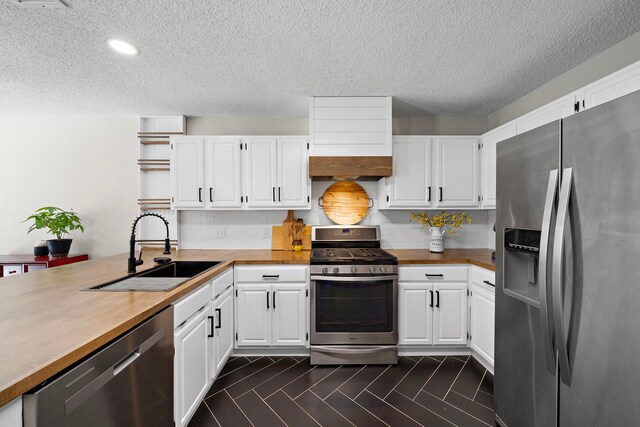 17203 Meadow Heights Dr, Houston, TX 77095 - kitchen with white cabinets, a textured ceiling, a sink, and appliances with stainless steel finishes