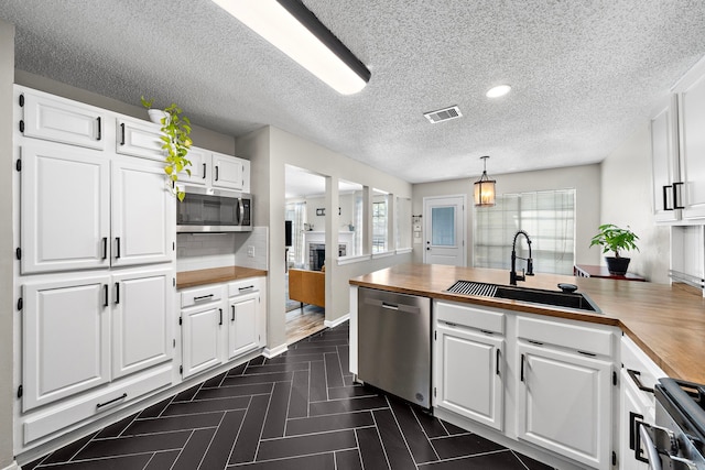 17203 Meadow Heights Dr, Houston, TX 77095 - kitchen featuring wood counters, white cabinetry, visible vents, appliances with stainless steel finishes, and a sink