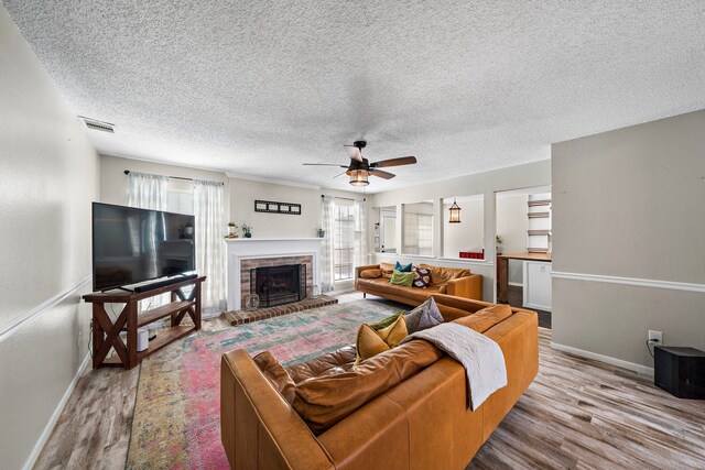 17203 Meadow Heights Dr, Houston, TX 77095 - living area featuring baseboards, a ceiling fan, a brick fireplace, visible vents, and wood finished floors