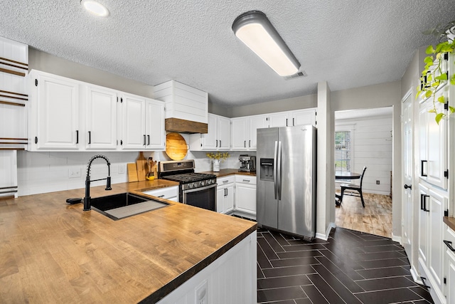 17203 Meadow Heights Dr, Houston, TX 77095 - kitchen featuring visible vents, a sink, appliances with stainless steel finishes, butcher block counters, and dark wood-style floors