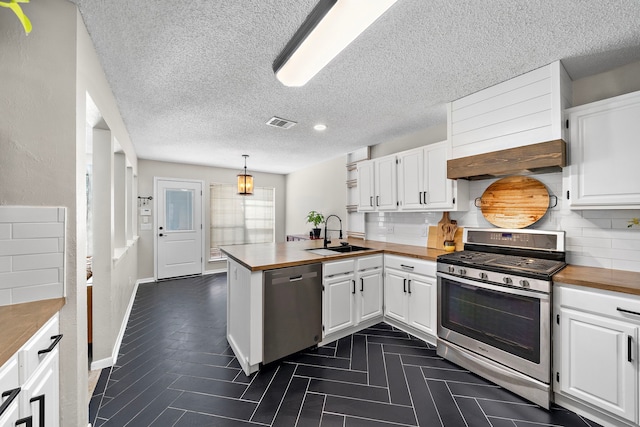 17203 Meadow Heights Dr, Houston, TX 77095 - kitchen with a peninsula, wooden counters, a sink, and appliances with stainless steel finishes