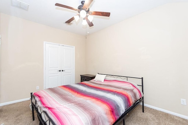 bedroom with a closet, baseboards, a ceiling fan, and carpet